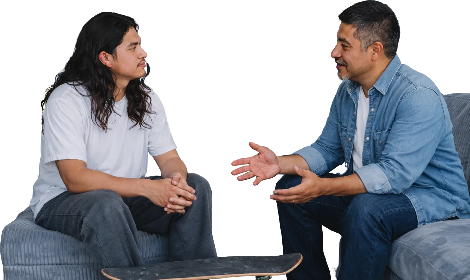 A veteran mentor talking with a young man on a couch
